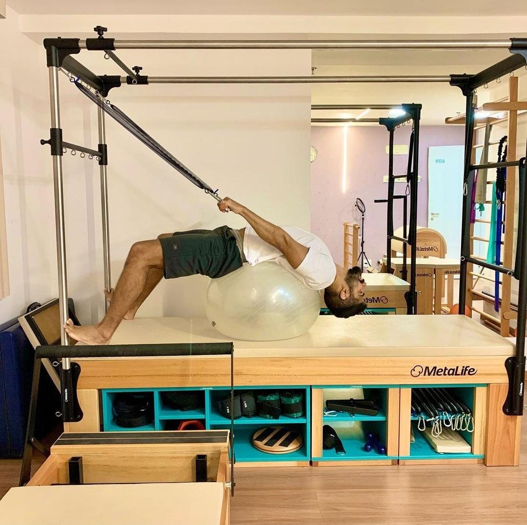 Aluno fazendo exercício no Cadillac com bola